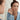 Young woman applying acne patch in front of mirror for clear skin