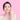 Smiling woman with clear skin pointing to her cheek after using Clarity Patch for acne treatment