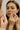 Woman looking in mirror popping pimples before using acne treatment